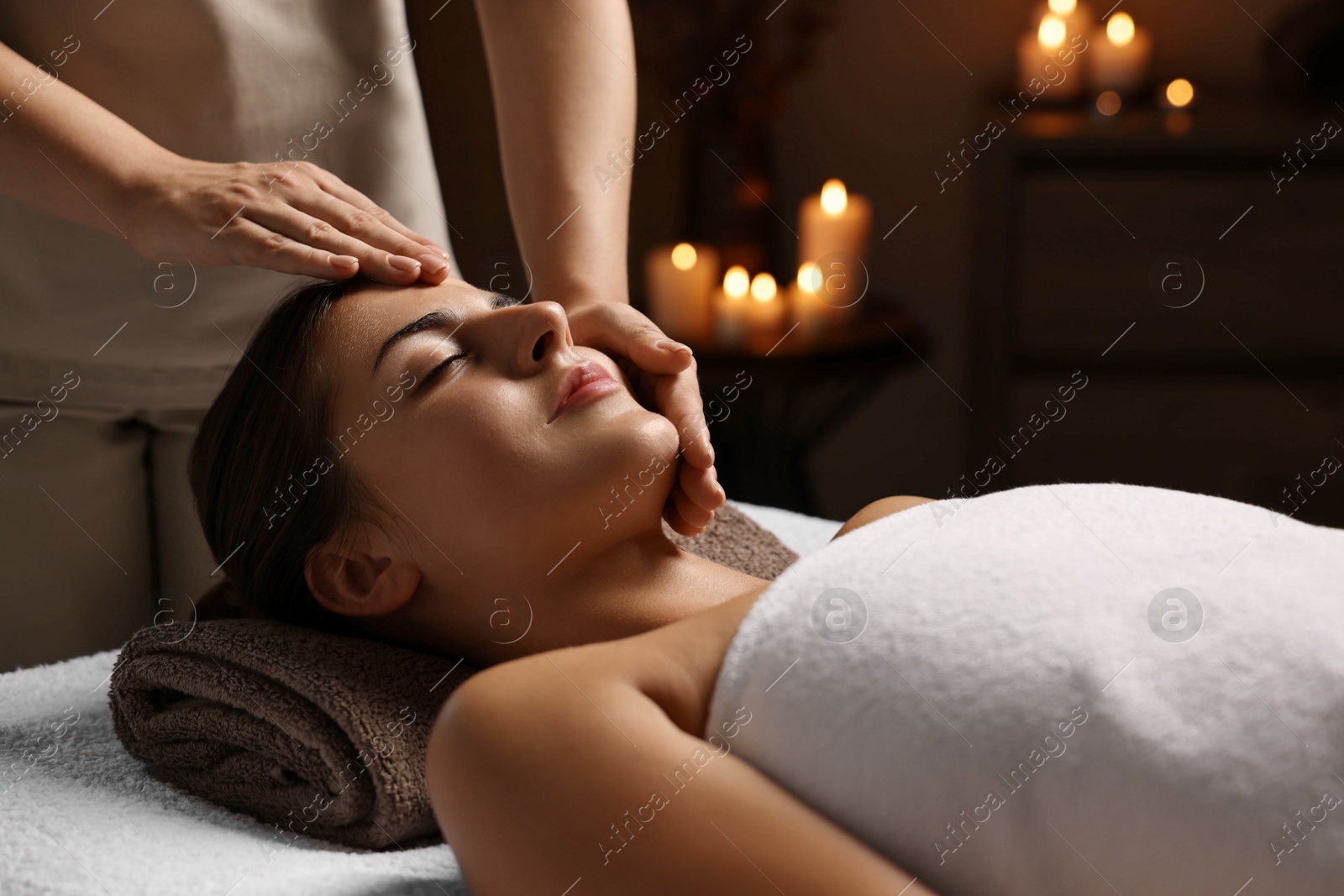 Photo of Attractive woman enjoying face massage, closeup. Beauty procedure