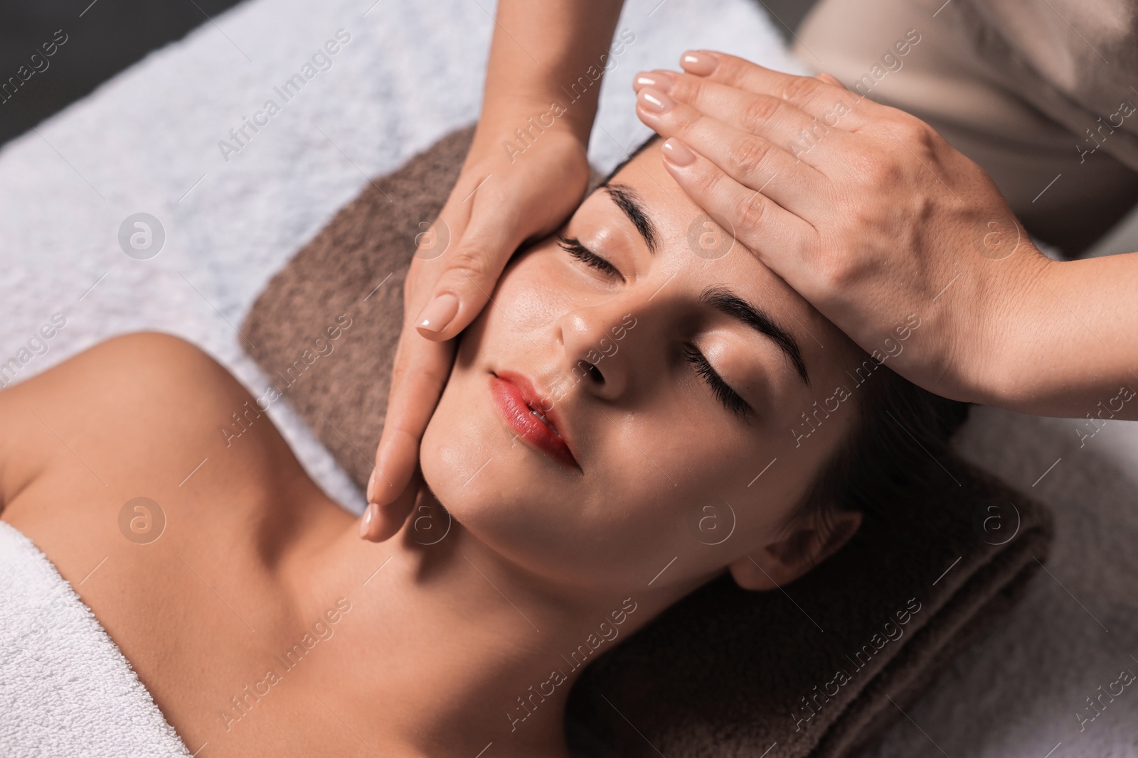 Photo of Attractive woman enjoying face massage, above view. Beauty procedure