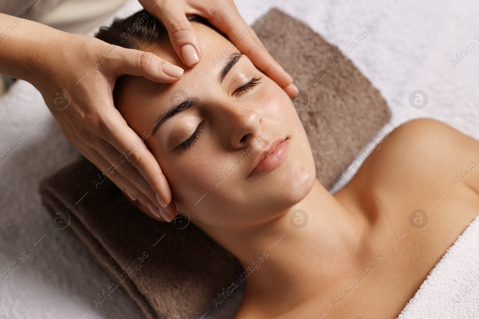 Photo of Attractive woman enjoying face massage, above view. Beauty procedure