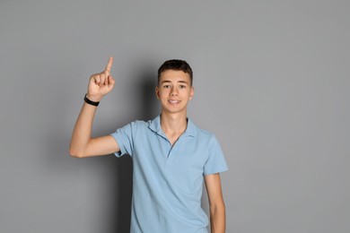 Photo of Portrait of teenage boy on grey background