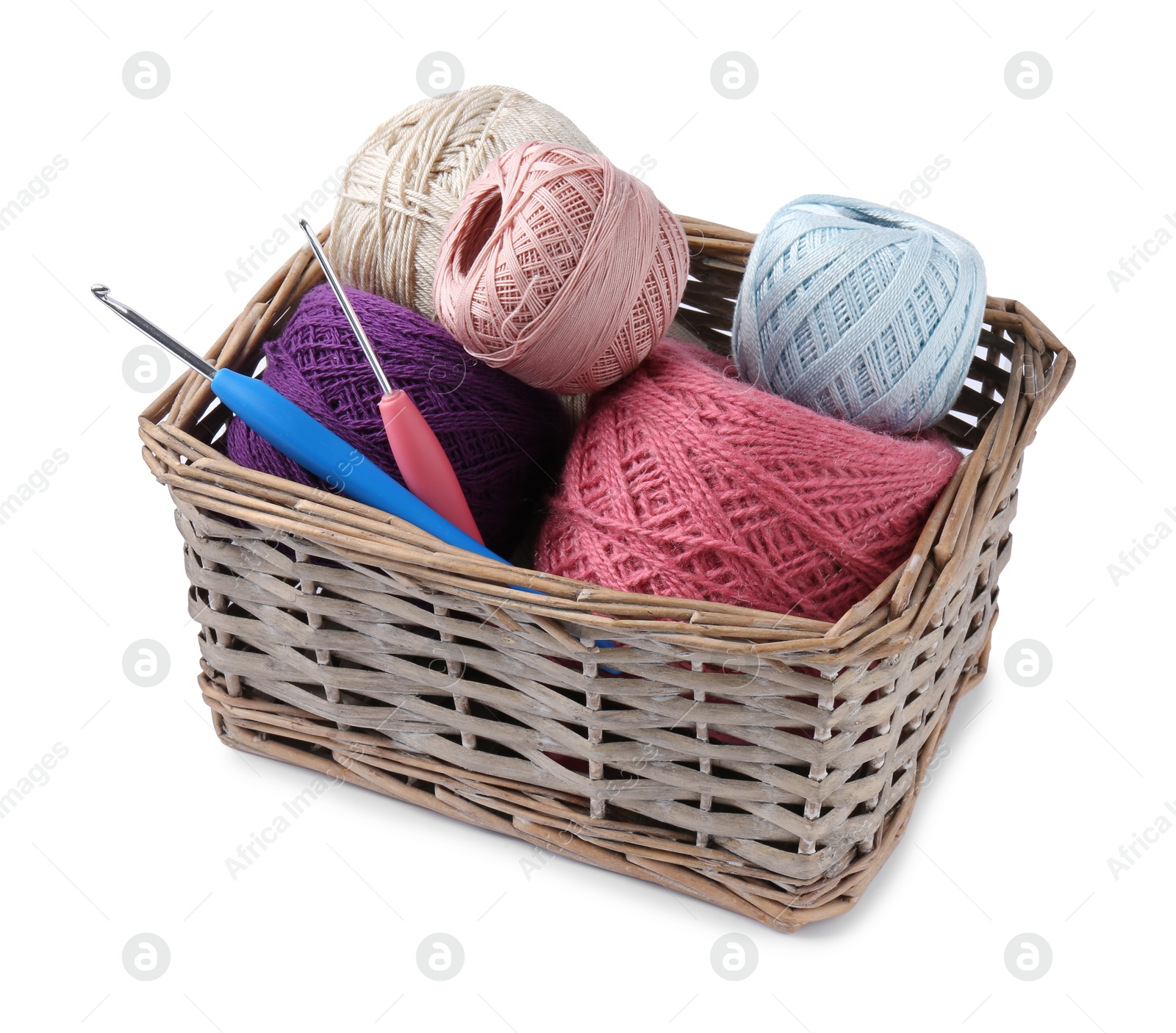 Photo of Many colorful yarns and crochet hooks in wicker basket isolated on white