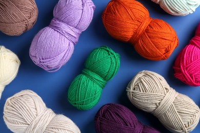 Photo of Different colorful yarns on blue background, flat lay