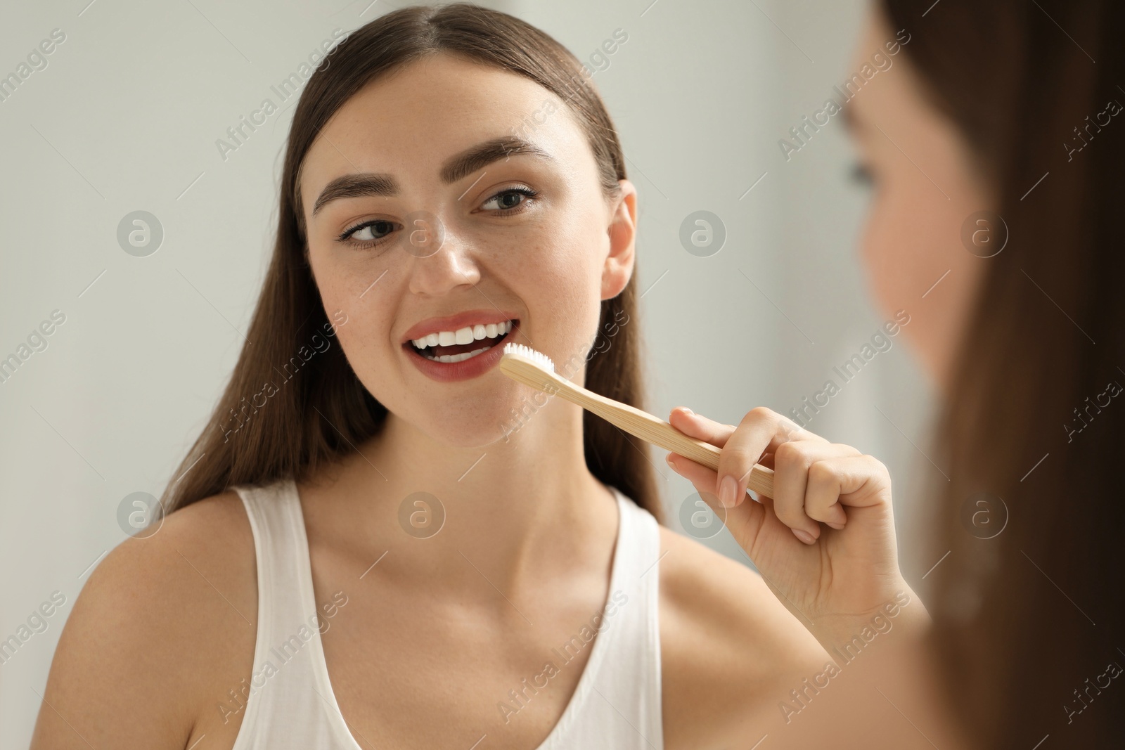 Photo of Beautiful woman brushing her teeth in bathroom