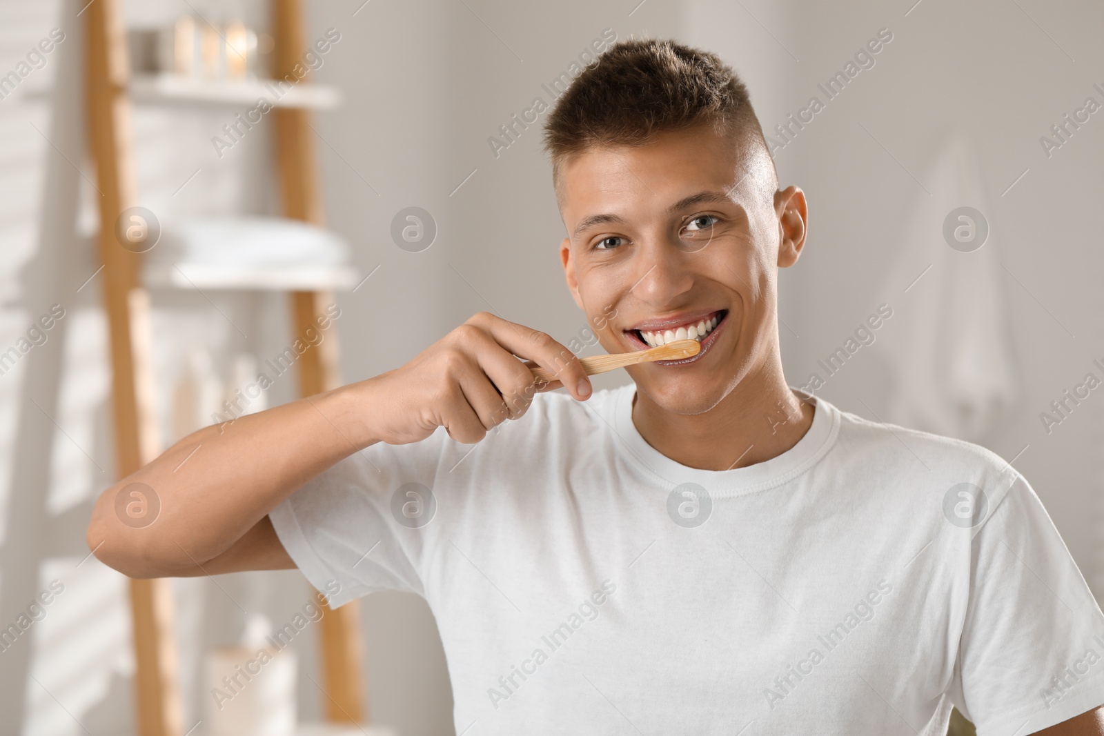 Photo of Young man brushing his teeth in bathroom