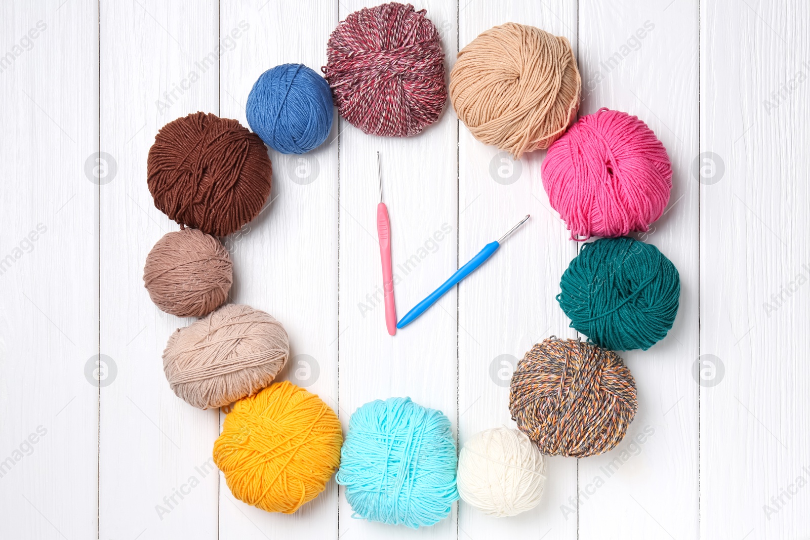 Photo of Clock made of colorful yarns and hooks on white wooden table, flat lay. Time to hobby