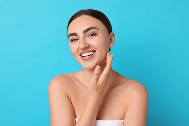 Photo of Face massage. Beautiful young woman with healthy skin on light blue background