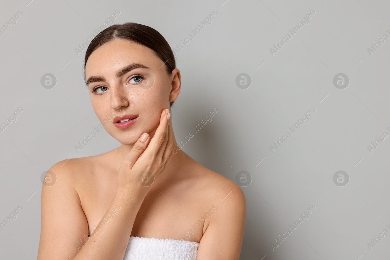 Photo of Beautiful young woman with healthy skin on grey background