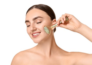 Beautiful young woman doing facial massage with roller on white background