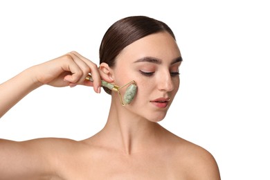 Beautiful young woman doing facial massage with roller on white background