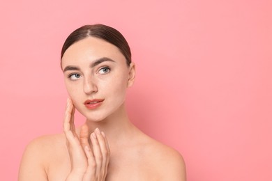 Beautiful young woman with healthy skin on pink background, space for text