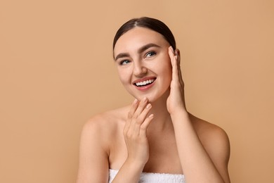 Photo of Face massage. Beautiful young woman with healthy skin on beige background