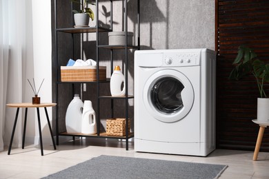 Photo of Washing machine and detergents in laundry room