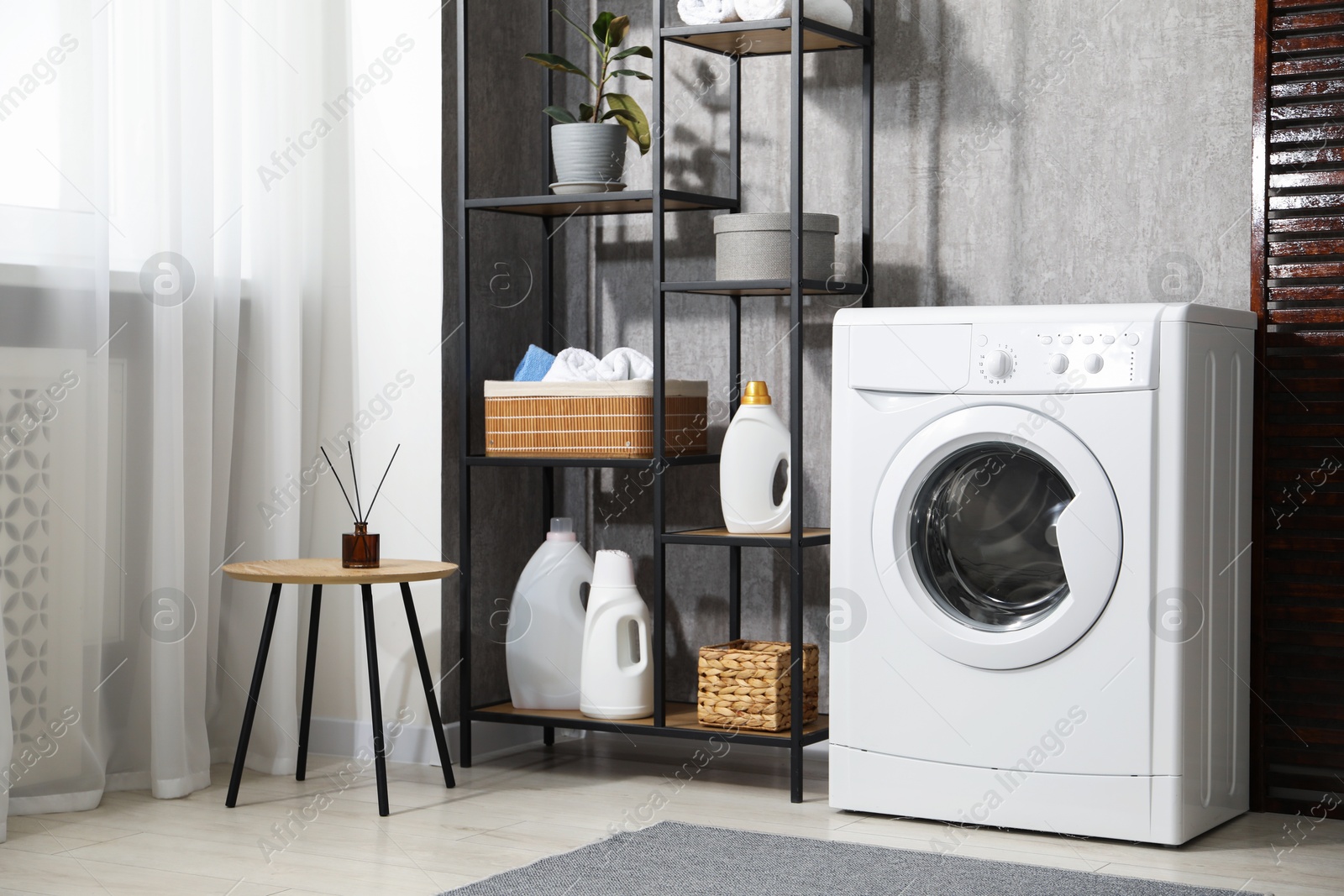 Photo of Washing machine and detergents in laundry room