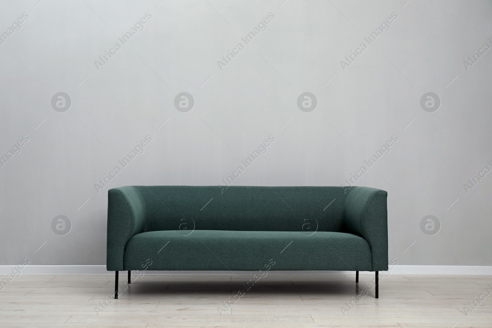 Photo of Comfortable sofa near light grey wall indoors, space for text