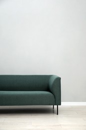 Photo of Comfortable sofa near light grey wall indoors, space for text