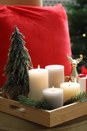 Photo of Tray with burning candles and Christmas decor on blurred background