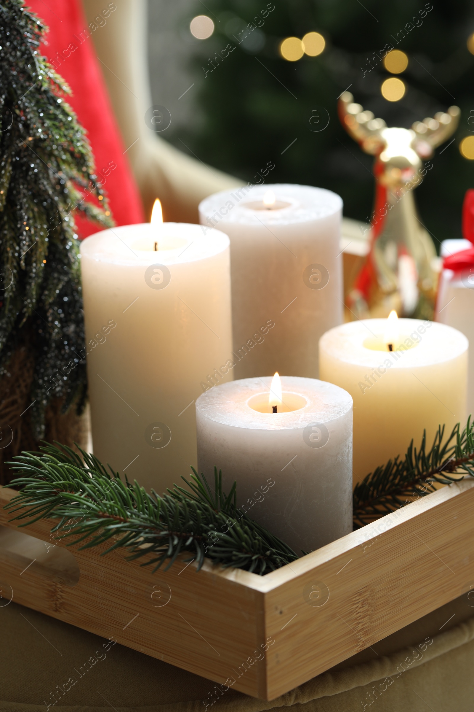 Photo of Tray with burning candles and Christmas decor on blurred background, closeup