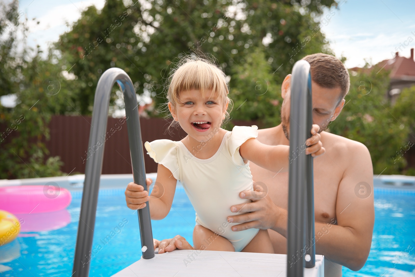 Photo of Family portrait of happy daughter and her father in swimming pool