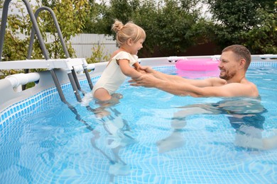 Happy daughter and her father having fun in swimming pool