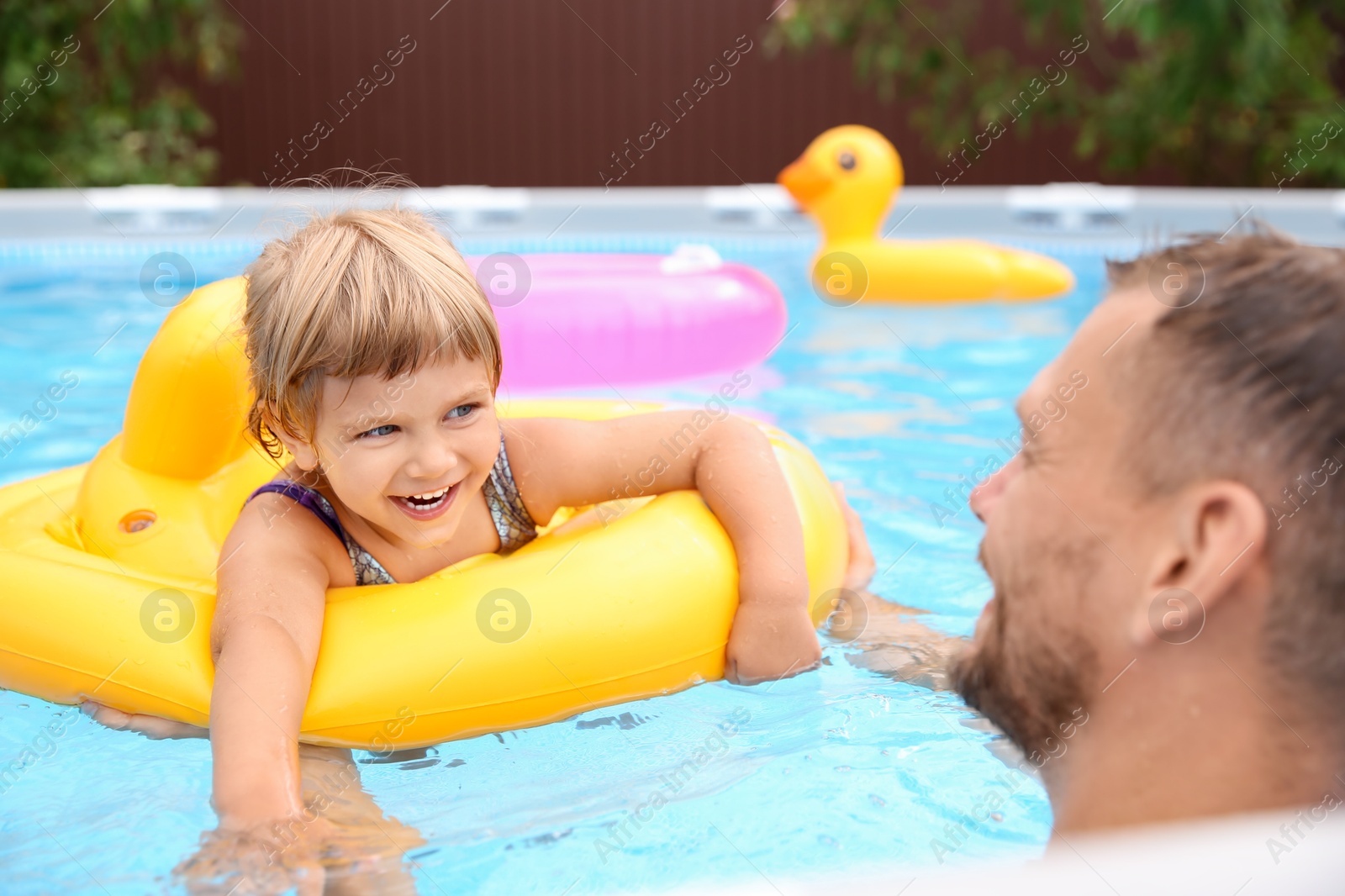 Photo of Happy daughter and her father having fun in swimming pool