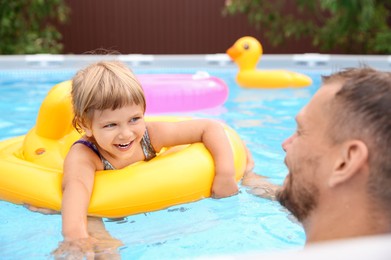 Happy daughter and her father having fun in swimming pool