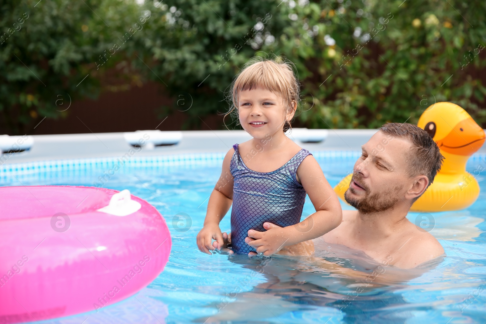 Photo of Daughter and her father having fun in swimming pool