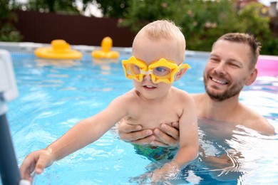 Happy father having fun with his son in swimming pool