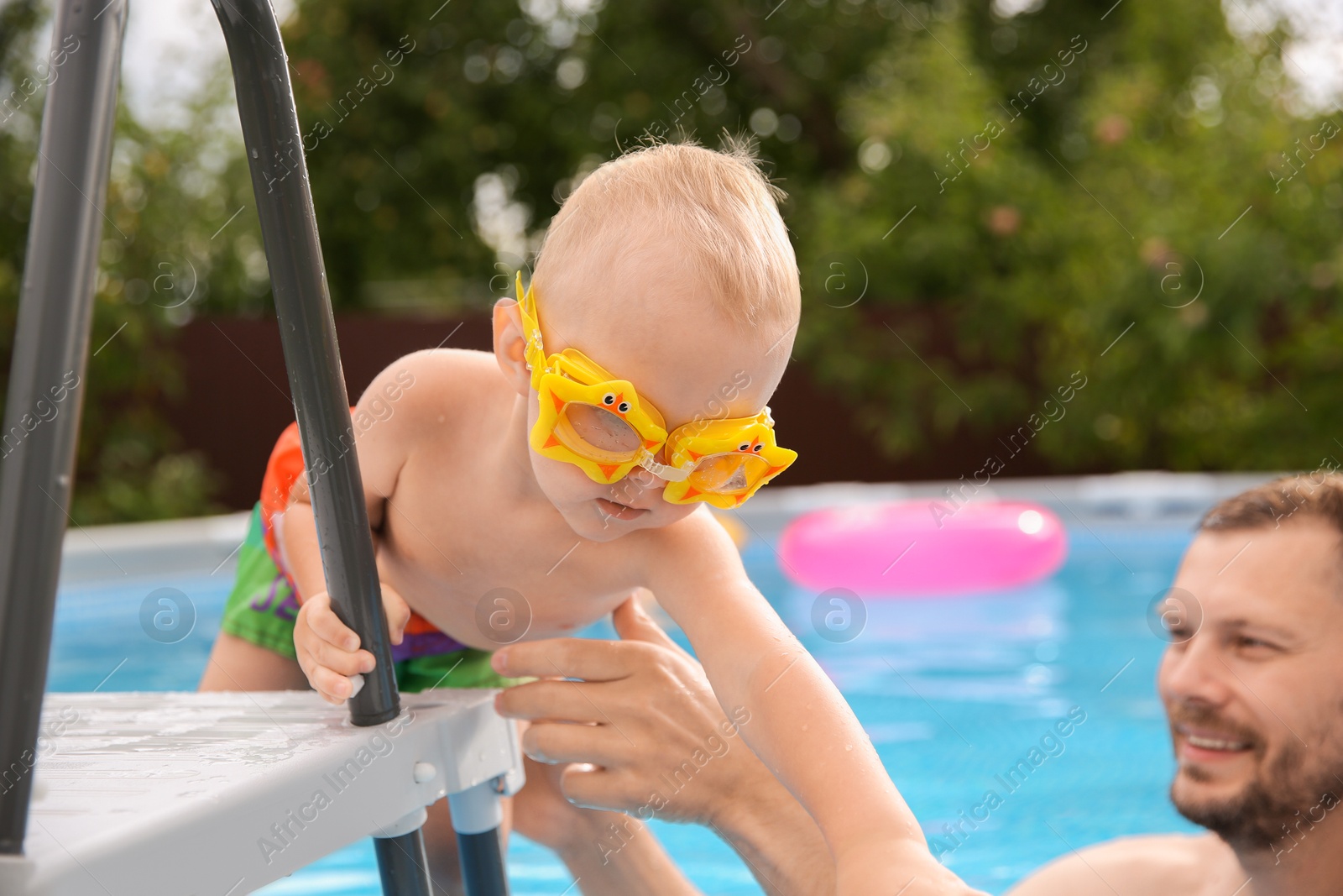 Photo of Happy father helping to his son getting out of swimming pool outdoors