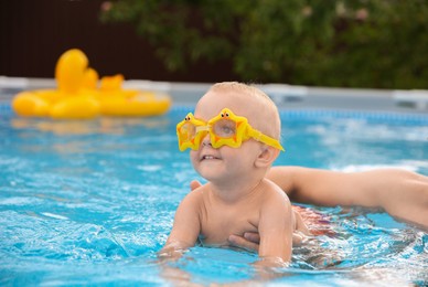 Photo of Father swimming with his son in pool, closeup