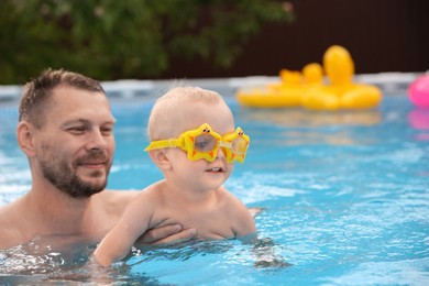 Photo of Father swimming with his son in pool