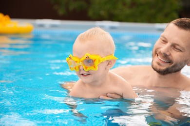 Happy father having fun with his son in swimming pool