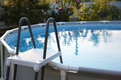 Above ground swimming pool with ladder outdoors