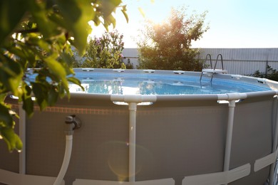 Photo of Above ground swimming pool in garden on sunny day