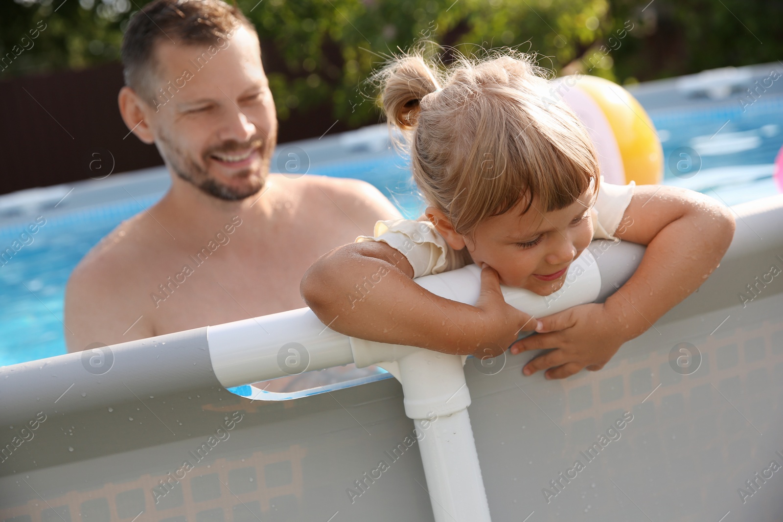 Photo of Happy father having fun with his daughter in swimming pool, selective focus