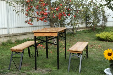 Photo of Wooden table with benches in apple garden