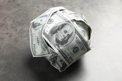 Photo of Ball made of dollars on grey table, closeup