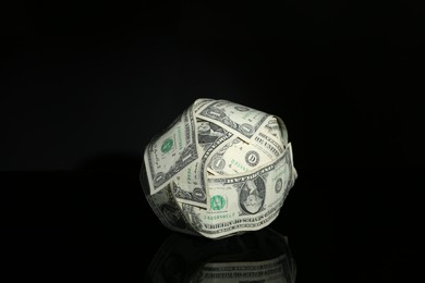 Ball made of dollars on black mirror surface