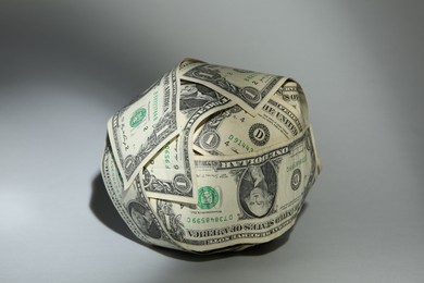 Photo of Ball made of dollars on grey background