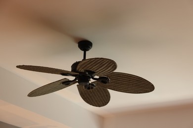 Photo of Modern ceiling fan indoors, low angle view