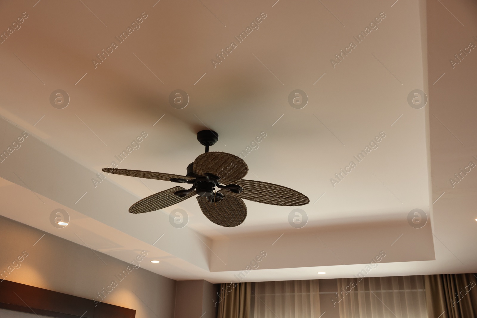 Photo of Modern ceiling fan indoors, low angle view