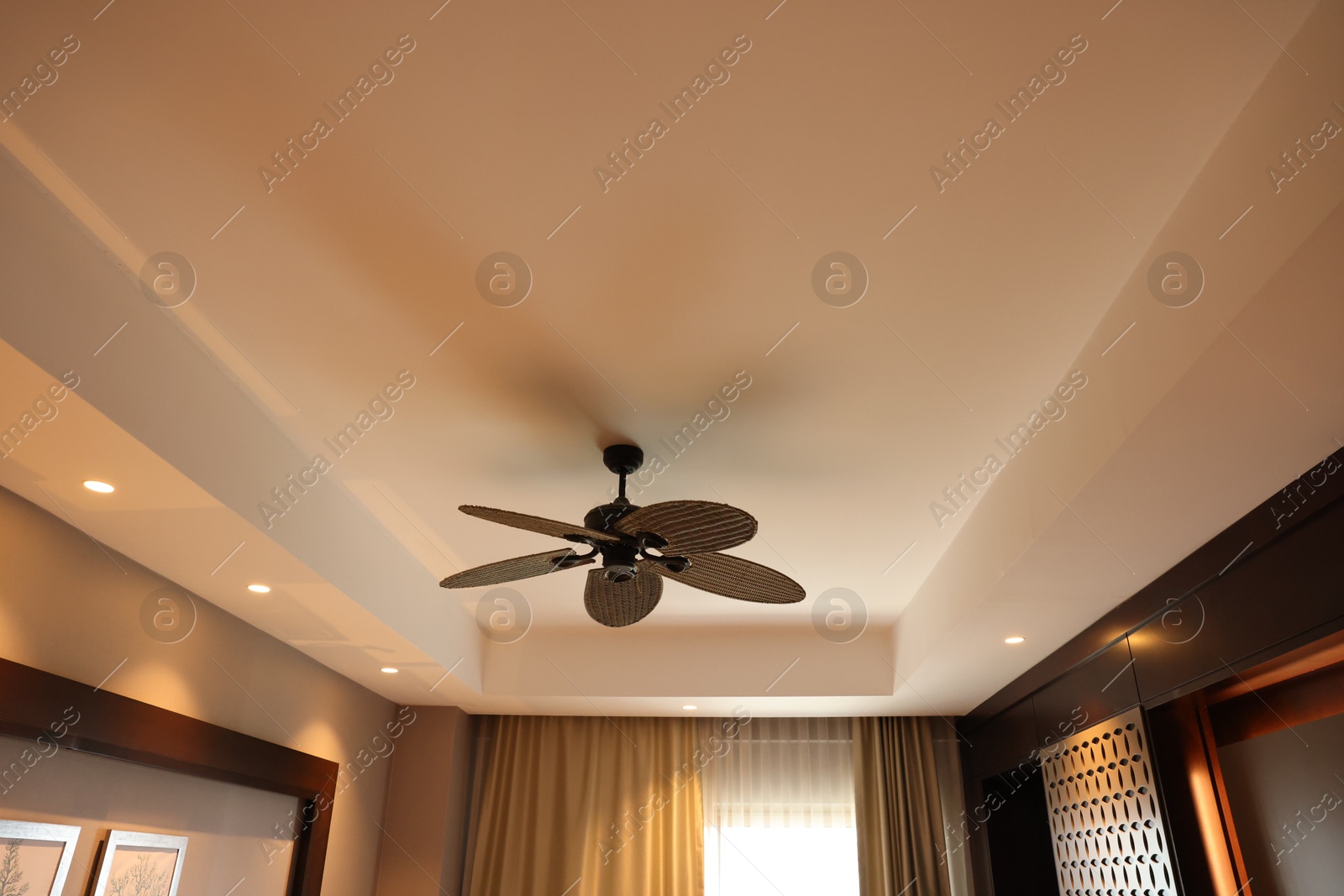 Photo of Modern ceiling fan indoors, low angle view