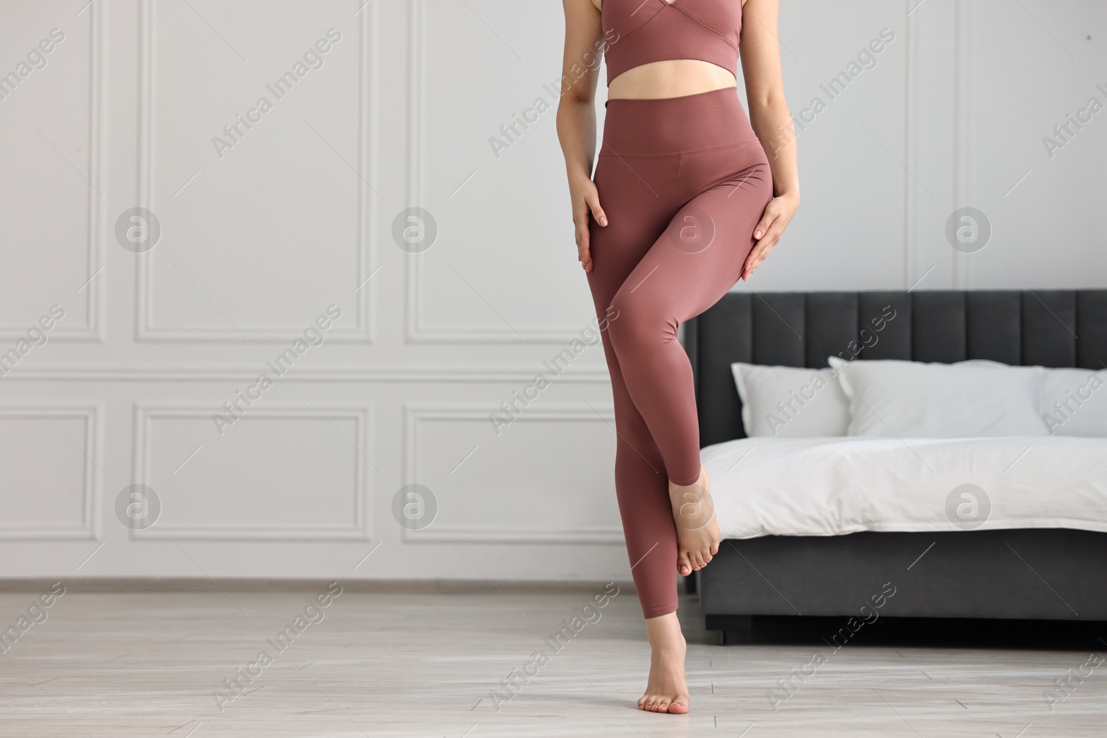 Photo of Woman wearing sports leggings indoors, closeup. Space for text