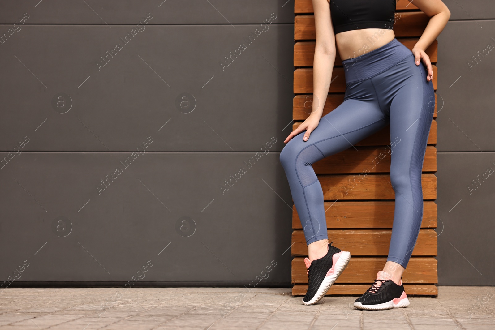 Photo of Woman wearing sports leggings outdoors, closeup. Space for text