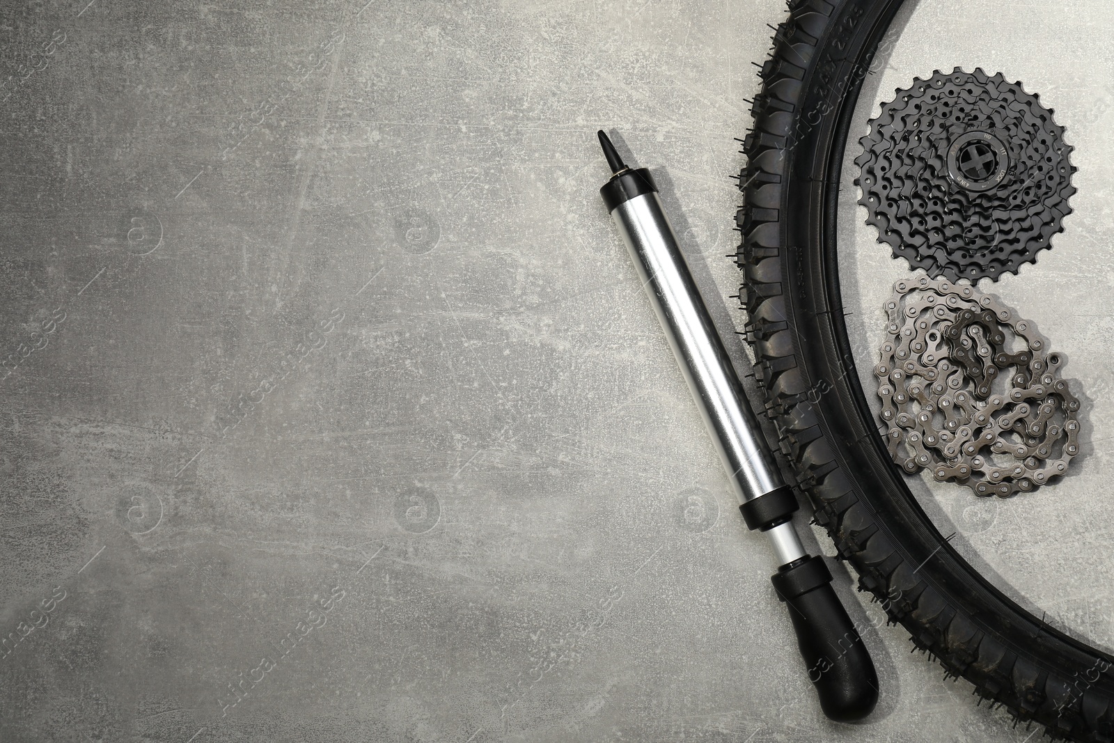 Photo of Parts of bicycle and tools on light grey table, flat lay. Space for text