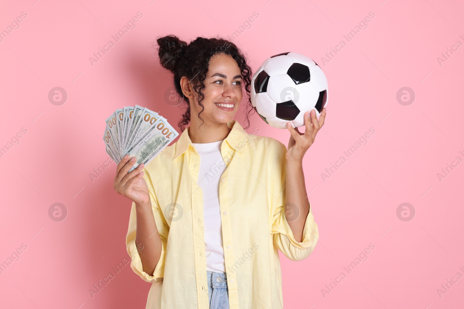 Photo of Happy woman with money and soccer ball on pink background