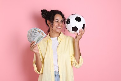 Happy woman with money and soccer ball on pink background