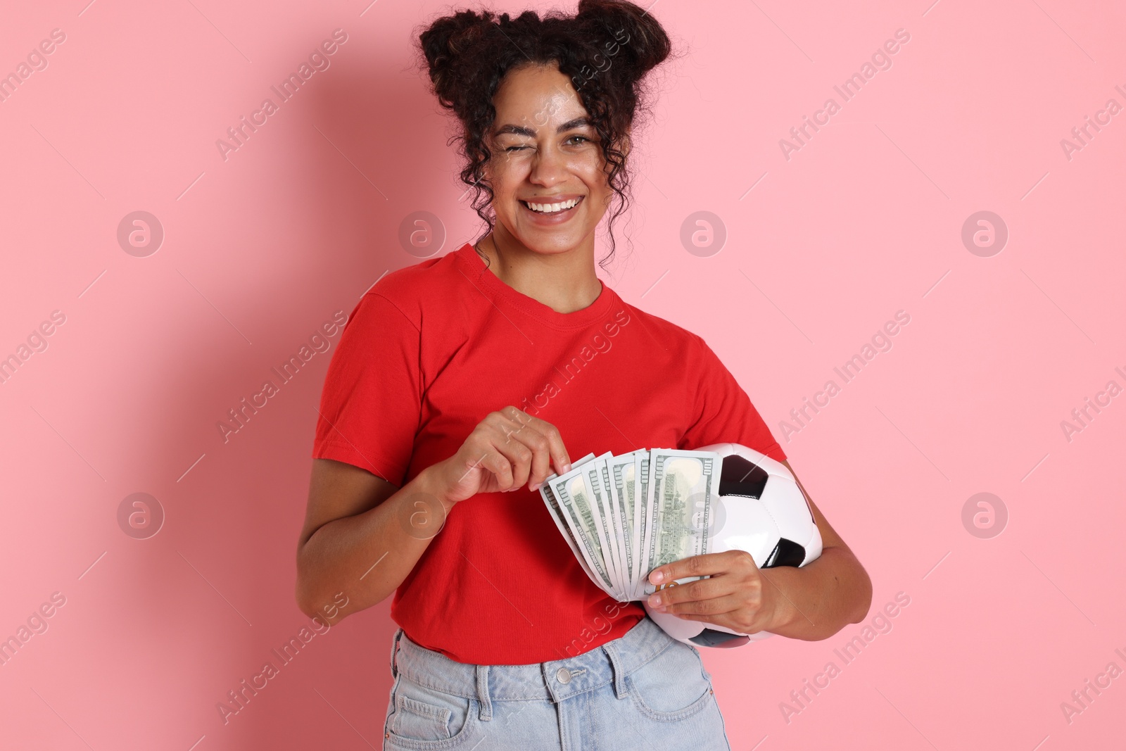 Photo of Happy woman with money and soccer ball on pink background