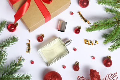 Photo of Christmas composition with perfume bottle on white background, flat lay