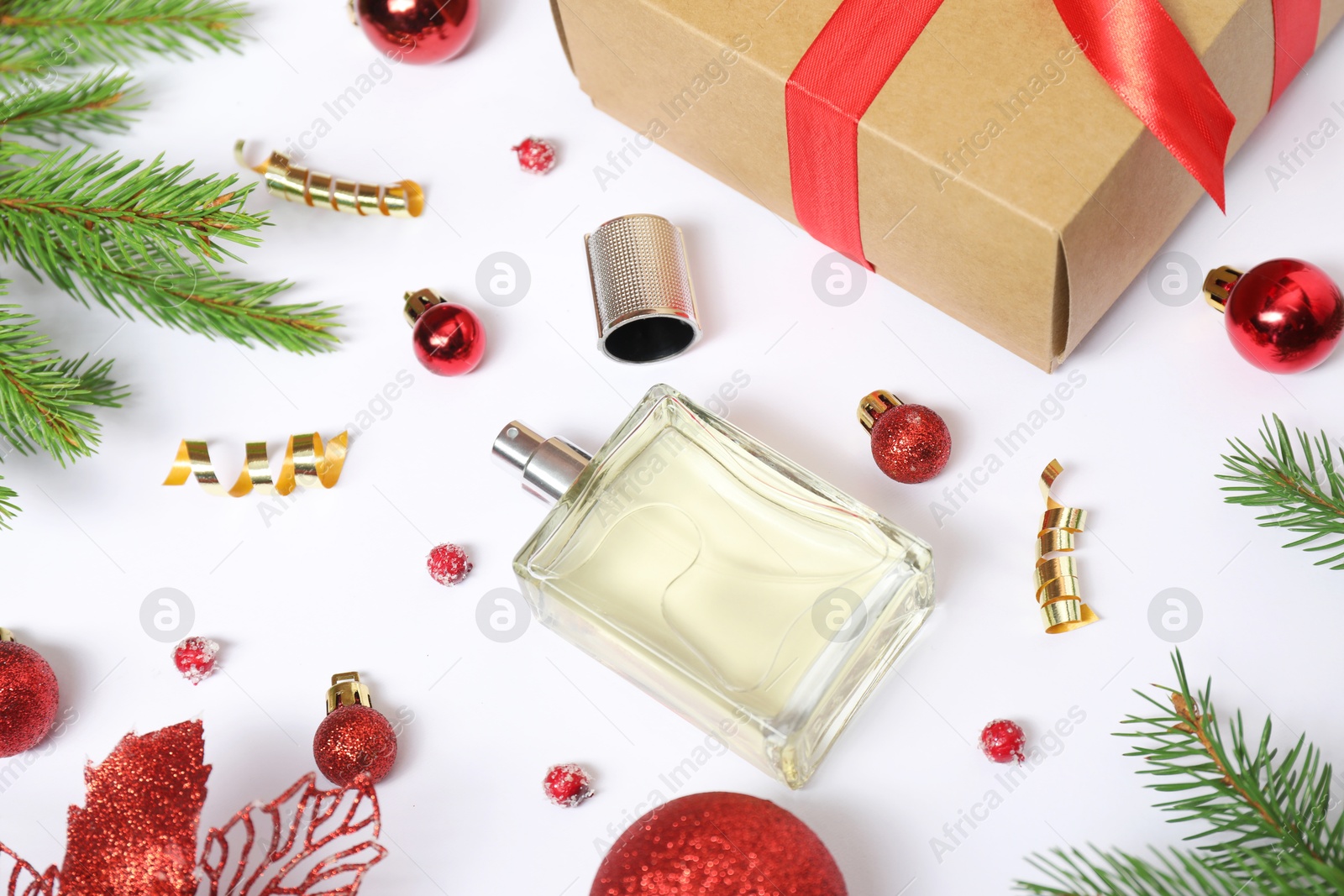 Photo of Composition with perfume bottle and Christmas decor on white background, above view