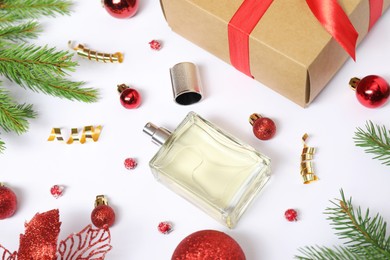 Composition with perfume bottle and Christmas decor on white background, above view